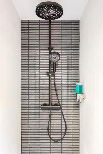 une douche avec pommeau de douche dans une salle de bain dans l'établissement Relais Cocorico Artist Studio glass roof with AC, à Paris