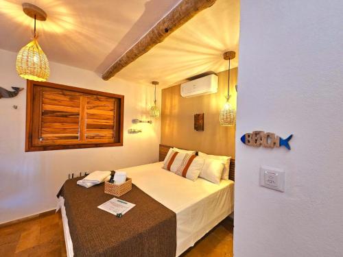 a small bedroom with a bed and a table at Chalés Mahalo J - Pontal de Maceió - Fortim in Fortim