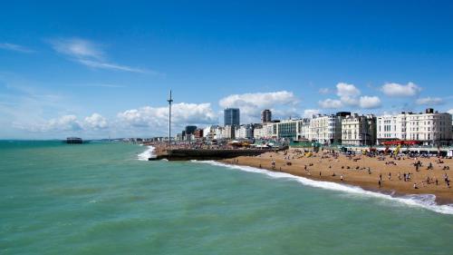 a group of people on a beach near the ocean at Holiday Inn Brighton Seafront by IHG in Brighton & Hove