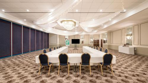 a conference room with a large white table and chairs at Holiday Inn Brighton Seafront by IHG in Brighton & Hove