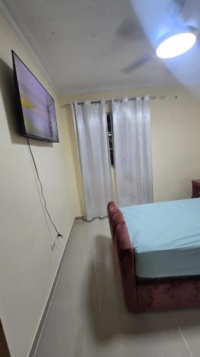 a room with a bed and a tv and a couch at Apartmento amueblado in Mendoza