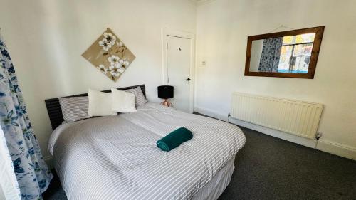 a bedroom with a bed with a green pillow on it at Ella street Double room in Hull