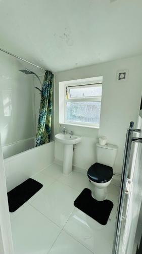 a white bathroom with a toilet and a sink at Ella street Double room in Hull