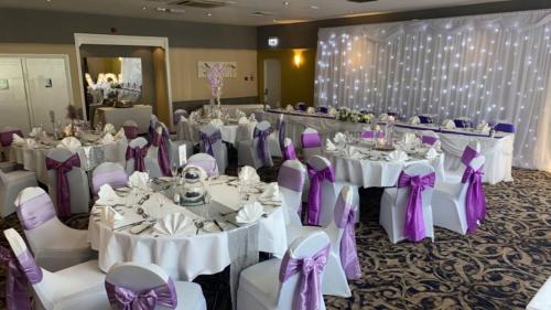 a banquet room with white tables and purple bows at Holiday Inn Washington by IHG in Washington