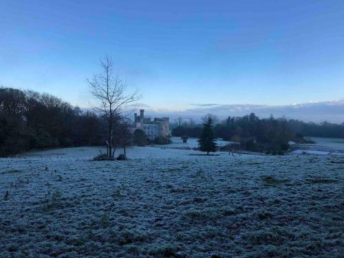a field covered in snow with a house in the background at Barmeath Castle Guest House in Dunleer