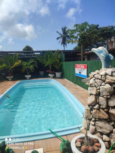 a large swimming pool in a resort with a dolphin at Pousada Miosotis in Nova Viçosa