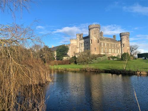 a castle with a lake in front of it at Barmeath Castle Guest House in Dunleer