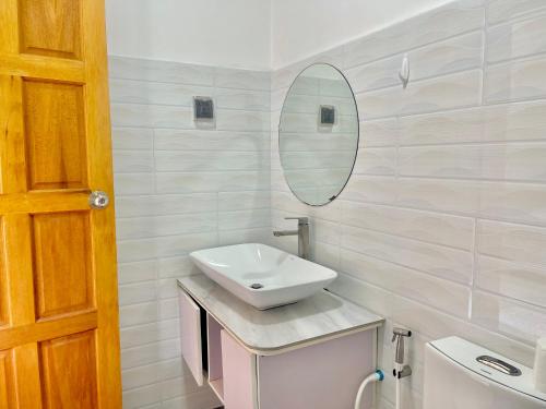 a white bathroom with a sink and a mirror at La Solara Villa in Ukulhas