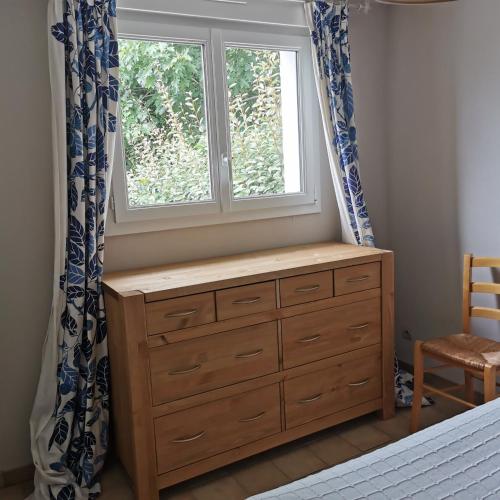- une chambre avec une commode et une fenêtre dans l'établissement Dépendance au calme dans notre jardin, à Saint-Aubin-des-Préaux