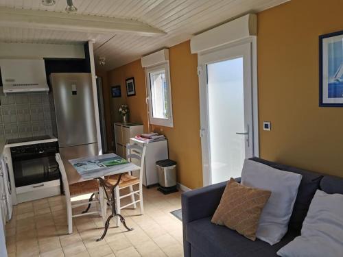 un salon avec un canapé et une table dans l'établissement Dépendance au calme dans notre jardin, à Saint-Aubin-des-Préaux