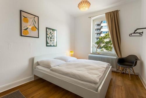 a bedroom with a bed and a chair and a window at MARBURGER Zentral, bis 8 Personen, WLAN, Netflix in Marburg an der Lahn