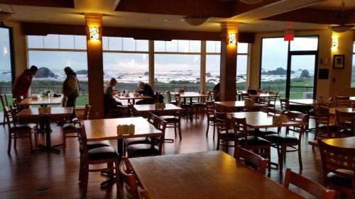 un restaurante con mesas y sillas con gente sentada a su lado en Oceanfront Lodge, en Crescent City