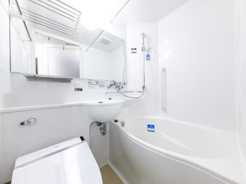 a white bathroom with a tub and a sink at APA Hotel Kyoto Ekikita in Kyoto