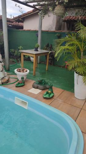 a swimming pool with a table and a picnic table at Pousada Miosotis in Nova Viçosa