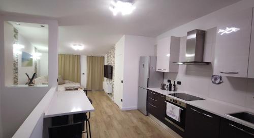 Una cocina con gabinetes blancos y una encimera blanca. en Caesar's luxury apartment in Lucca Center town Roman Amphitheater, en Lucca