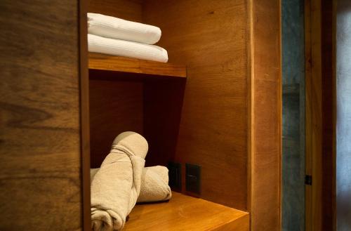 a towel is sitting on a shelf in a closet at Casa del Viento by ÓOL Hotels in Holbox Island