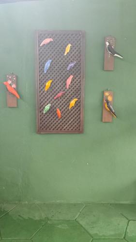 a wall with a painting on a wall with two knives at Pousada Miosotis in Nova Viçosa
