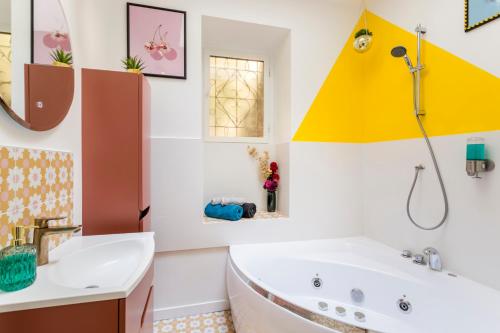 une salle de bain avec une baignoire et un lavabo dans l'établissement Relais Cocorico - Cocon proche tour Eiffel avec baignoire Balnéo, à Paris