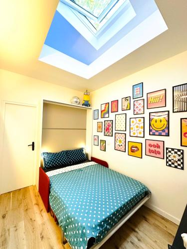 une chambre avec un lit et une lucarne dans l'établissement Relais Cocorico - Cocon proche tour Eiffel avec baignoire Balnéo, à Paris