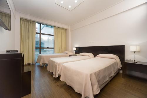 Ένα ή περισσότερα κρεβάτια σε δωμάτιο στο Hotel Versailles