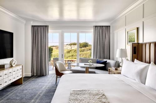 a hotel room with a king bed and a living room at The Ritz-Carlton, Half Moon Bay in Half Moon Bay