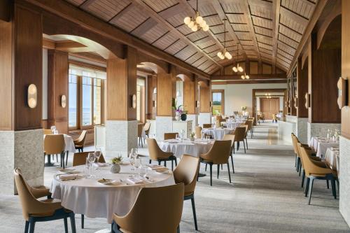 a dining room with white tables and chairs at The Ritz-Carlton, Half Moon Bay in Half Moon Bay