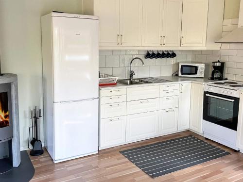 a kitchen with white cabinets and a white refrigerator at 6 person holiday home in Olofström-By Traum in Olofström