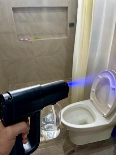 a person holding a camera in front of a toilet at Hospedaje Nacho y Ale No 1, Paso Canoas, Costa Rica in Canoas