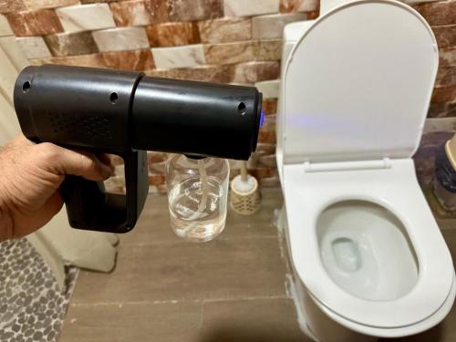 a person holding a toilet paper dispenser in a bathroom at Hospedaje Nacho y Ale No 1, Paso Canoas, Costa Rica in Canoas