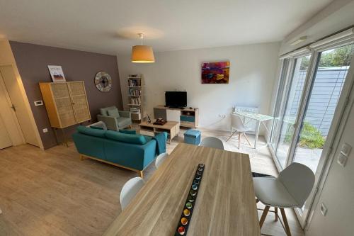 un salon avec une table et un canapé dans l'établissement Apartment 5 minutes from the beach, à Lion-sur-Mer