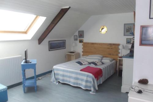 une chambre avec un grand lit avec une tête de lit en bois dans l'établissement Agreable maison de pecheur a 2 pas du port, à La Trinité-sur-Mer