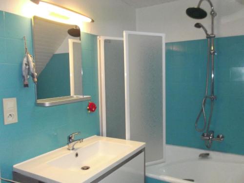 une salle de bain avec un lavabo, un miroir et une baignoire dans l'établissement Agreable maison de pecheur a 2 pas du port, à La Trinité-sur-Mer