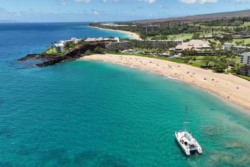 a boat in the water next to a beach at Sheraton Maui Resort & Spa in Lahaina
