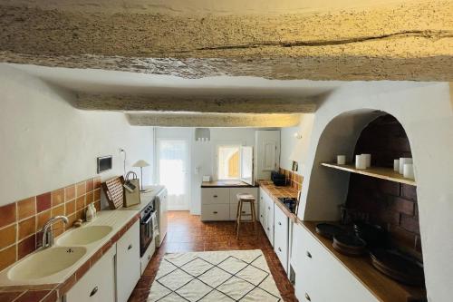 une grande cuisine avec un évier et un comptoir dans l'établissement La Maison Maupas, à Ménerbes