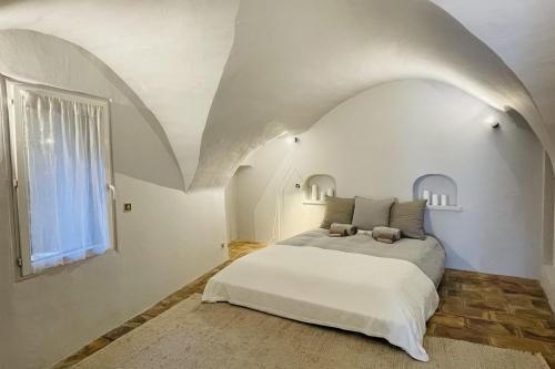 une chambre avec un lit dans une pièce blanche dans l'établissement La Maison Maupas, à Ménerbes