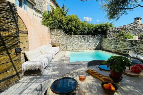 une terrasse avec un canapé et une piscine dans l'établissement La Maison Maupas, à Ménerbes