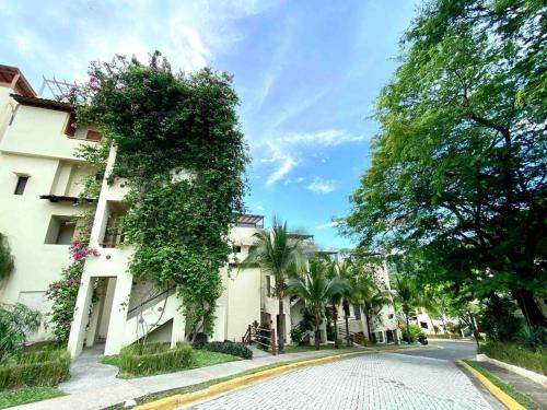 a cobblestone street in front of a white building at Peaceful Bliss Condo Inside A 6 Pool Complex in Coco