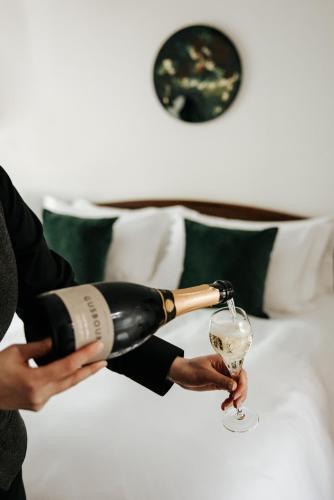 a person is pouring a glass of wine at Edinbane Lodge in Edinbane