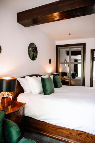 a bedroom with a large white bed with green pillows at Edinbane Lodge in Edinbane