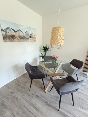 a dining room with a glass table and chairs at Mooi en trendy appartement vlakbij strand in Vlissingen
