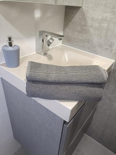 a bathroom sink with a gray towel on it at Mooi en trendy appartement vlakbij strand in Vlissingen