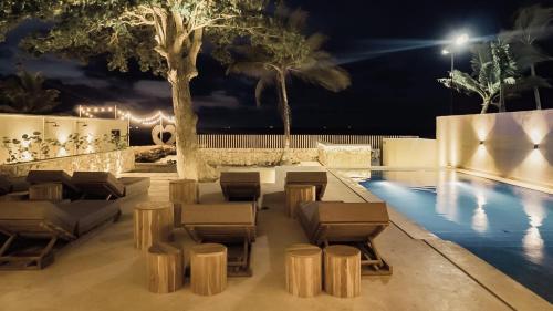 a swimming pool with chairs and a table and a swimming pool at Talam House Coveñas by Bernalo Hotels in Coveñas