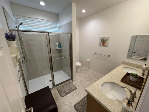 a bathroom with a glass shower and a sink at New Tropical Island Ohana near Beach with community Pool Spa Gym PingPong and more in Waianae