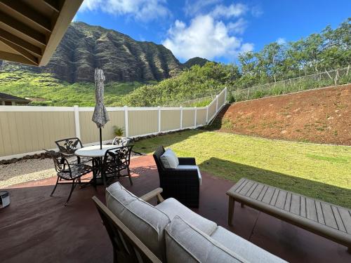 a patio with a couch and a table and chairs at New Tropical Island Ohana near Beach with community Pool Spa Gym PingPong and more in Waianae