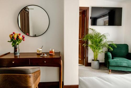 a bedroom with a green chair and a mirror at Edinbane Lodge in Edinbane