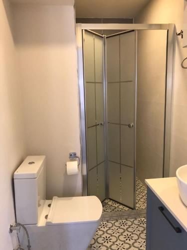 a bathroom with a toilet and a glass shower at La Maison de Yasmine in Alaçatı