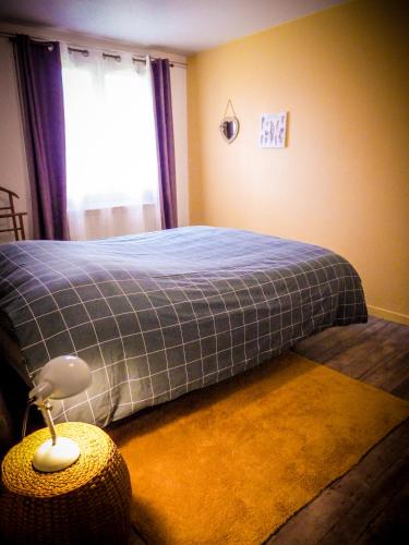 une chambre avec un lit avec une couverture bleue dans l'établissement Grand appartement au calme, à Lérouville