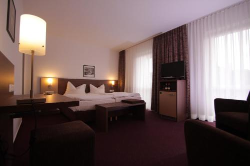 a hotel room with a bed and a desk and a couch at Hotel Buntrock in Holzminden