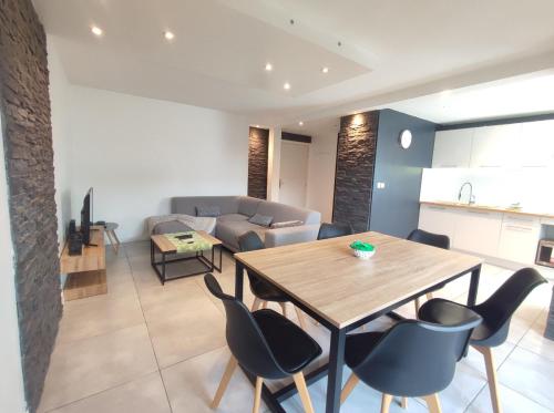 un salon avec une table, des chaises et un canapé dans l'établissement Superbe appartement, à Aucamville