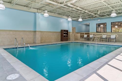 a swimming pool with blue water in a building at Holiday Inn Express & Suites Detroit - Novi by IHG in Novi